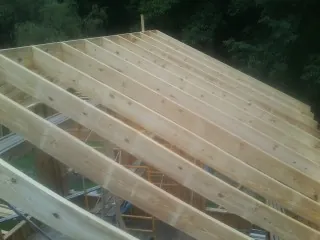New roof rafters set over an addition before sheathing in Colt