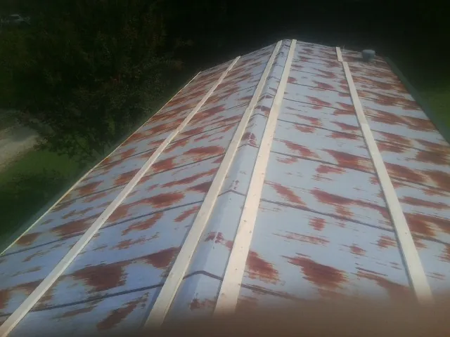 Rusted metal roof panels with new wood purlins before replacement — Storm Damage Roof Repair in Colt by Roofing Brothers
